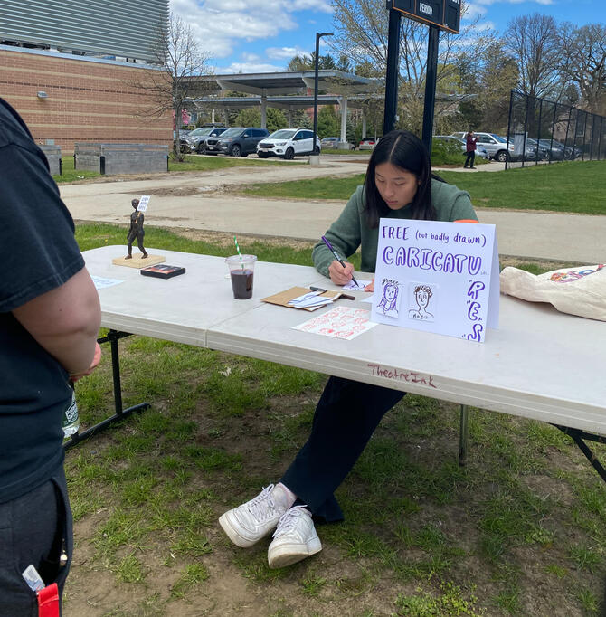 Artist Rebecca Yao draws free caricatures for attendees.